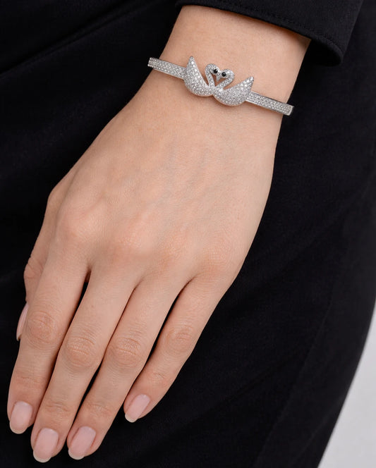 Woman wearing a 925 sterling silver swan bracelet with sparkling cubic zirconia stones by SVARNAVI.